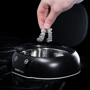Diamond grillz being placed into Soniq Clean ultrasonic jewellery cleaner