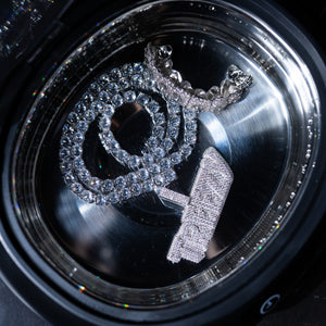 Tennis chain, grillz and moissanite diamond pendant inside Soniq Clean stainless steel tank